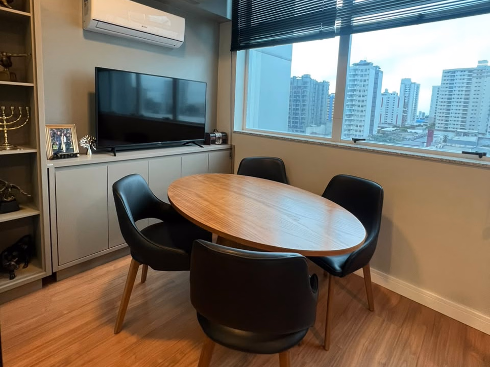 Ambiente de reuniões com mesa redonda e vista da cidade